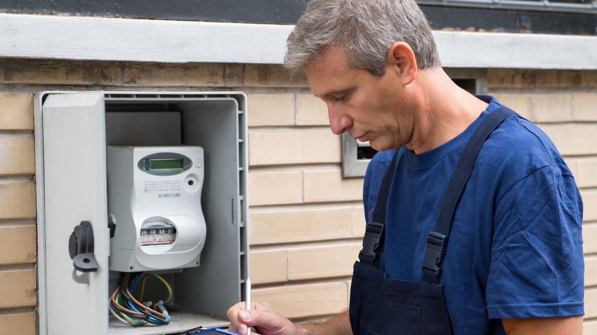 Technicien notant un relevé devant un coffret compteur